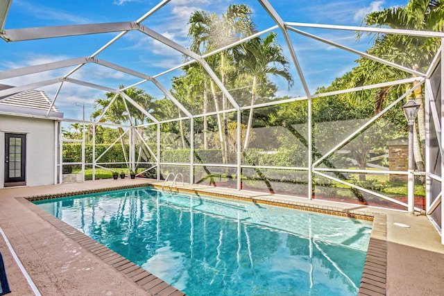 view of swimming pool with glass enclosure and a patio area