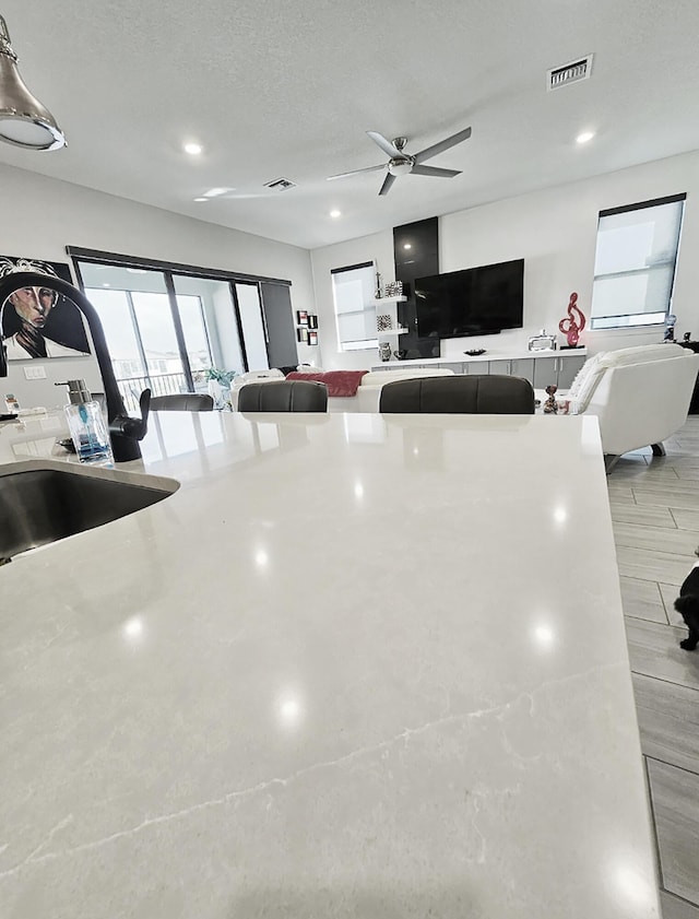 kitchen with ceiling fan, sink, and a textured ceiling