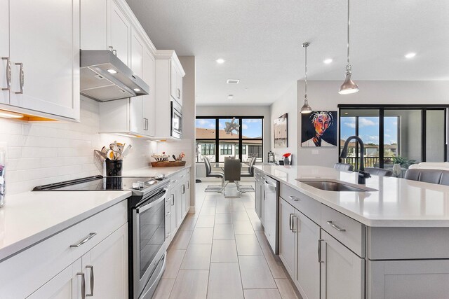 kitchen featuring ceiling fan, sink, and a textured ceiling