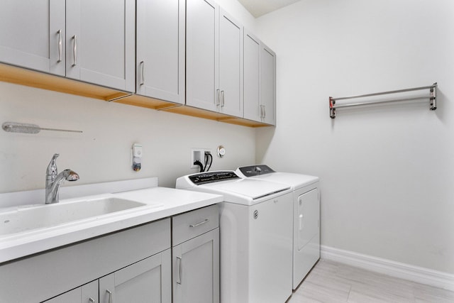 laundry area featuring cabinets, sink, and washing machine and clothes dryer