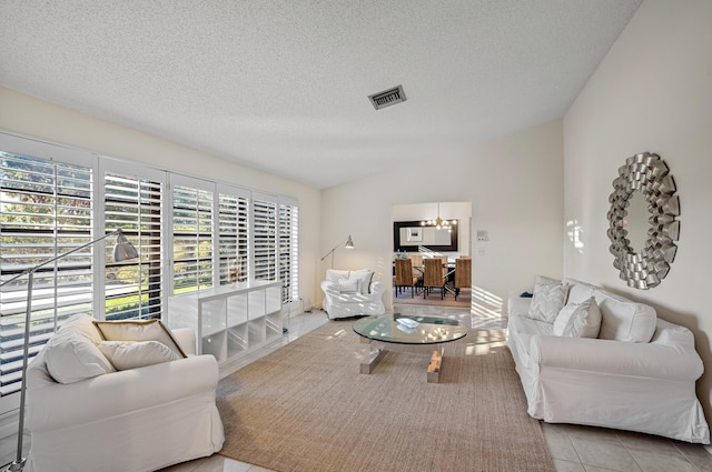 tiled living room with an inviting chandelier, lofted ceiling, and a textured ceiling