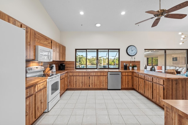 kitchen with backsplash, white appliances, a wealth of natural light, and light tile patterned floors