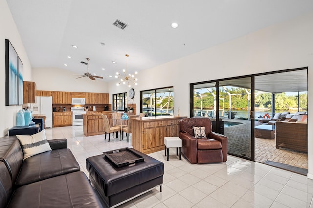 living room with ceiling fan with notable chandelier, high vaulted ceiling, and light tile patterned floors