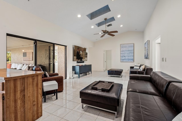 tiled living room with high vaulted ceiling, ceiling fan, and a skylight