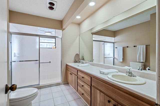 bathroom featuring vanity, walk in shower, toilet, tile patterned floors, and a textured ceiling