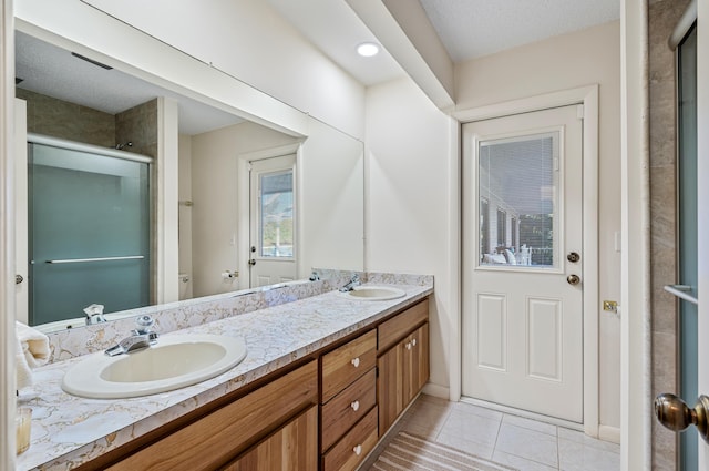 bathroom featuring vanity, a textured ceiling, tile patterned floors, and toilet