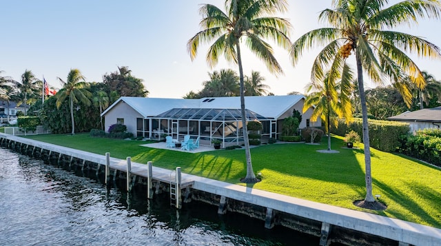back of house featuring a yard, a lanai, and a water view