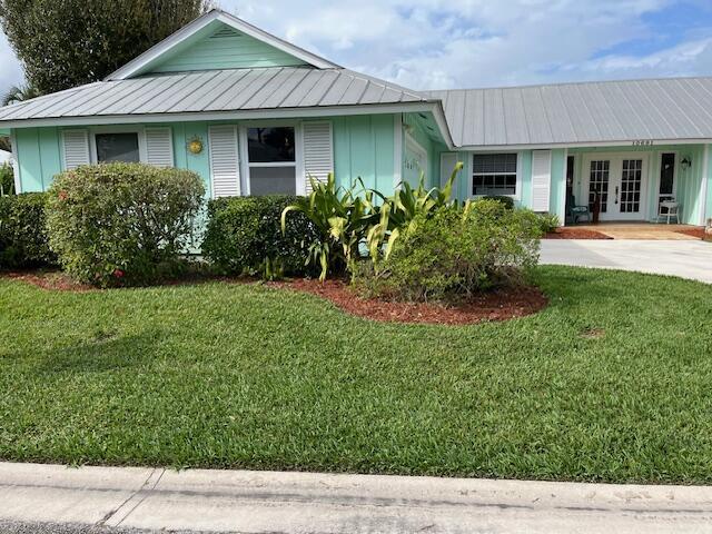 view of front of home with french doors and a front lawn