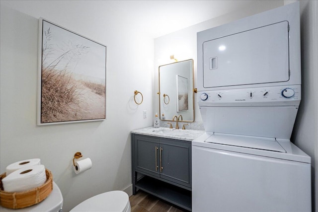 1300 Seaway Dr Unit B6, Fort Pierce, FL 34949 - bathroom with toilet, vanity, stacked washing maching and dryer, and hardwood / wood-style floors