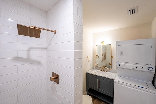 1300 Seaway Dr Unit B6, Fort Pierce, FL 34949 - bathroom featuring tiled shower, stacked washer / drying machine, toilet, and vanity