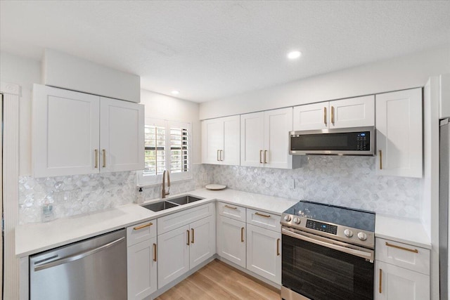 1300 Seaway Dr Unit B6, Fort Pierce, FL 34949 - kitchen featuring sink, stainless steel appliances, light hardwood / wood-style floors, and white cabinets