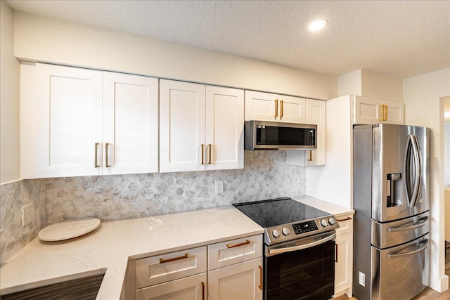 1300 Seaway Dr Unit B6, Fort Pierce, FL 34949 - kitchen with white cabinetry, light stone counters, tasteful backsplash, and appliances with stainless steel finishes