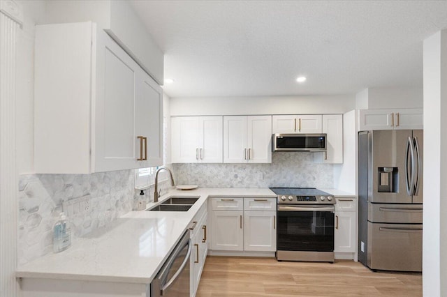 1300 Seaway Dr Unit B6, Fort Pierce, FL 34949 - kitchen featuring sink, light hardwood / wood-style flooring, white cabinetry, stainless steel appliances, and decorative backsplash