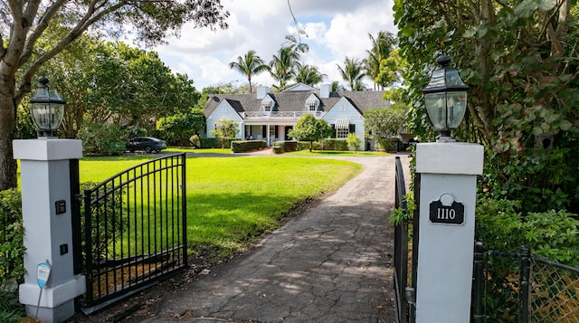 exterior space featuring a gate, fence, and a front lawn