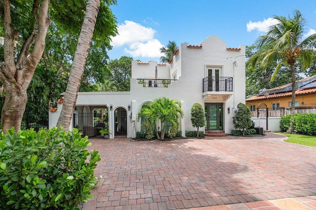 mediterranean / spanish-style house with a balcony and french doors