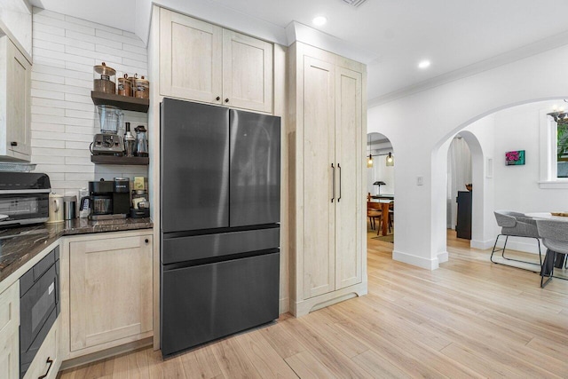 kitchen featuring refrigerator, black microwave, ornamental molding, light brown cabinets, and light hardwood / wood-style flooring