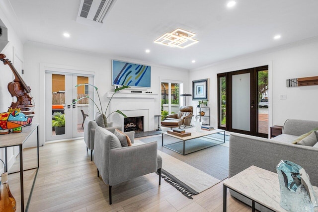 living room with ornamental molding, light hardwood / wood-style floors, and french doors