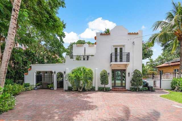 mediterranean / spanish-style house featuring a balcony and french doors