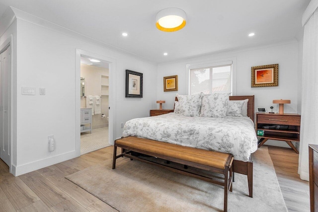 bedroom with crown molding, ensuite bath, and light hardwood / wood-style floors