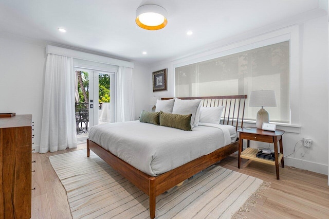 bedroom with access to exterior, light hardwood / wood-style flooring, and french doors