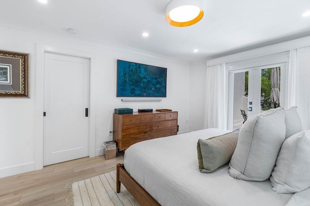 bedroom with light hardwood / wood-style flooring, ornamental molding, and french doors