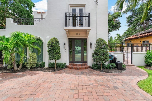 property entrance featuring a balcony and french doors