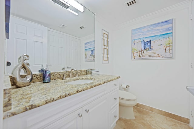 bathroom with tile patterned flooring, vanity, crown molding, and toilet