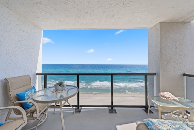 balcony featuring a water view and a beach view