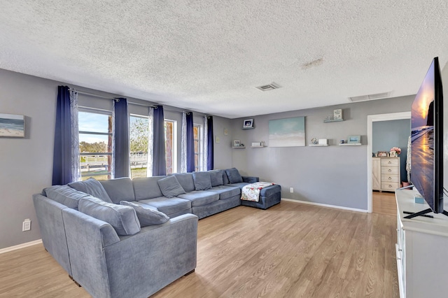 living room featuring light hardwood / wood-style floors and a textured ceiling