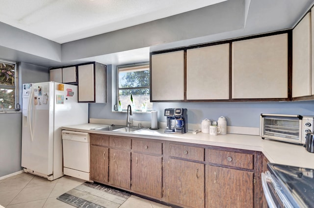 kitchen with light tile patterned flooring, sink, and white appliances