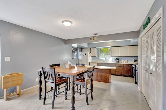 tiled dining room featuring sink