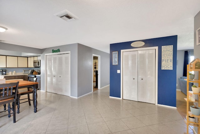 dining room featuring a textured ceiling and light tile patterned floors