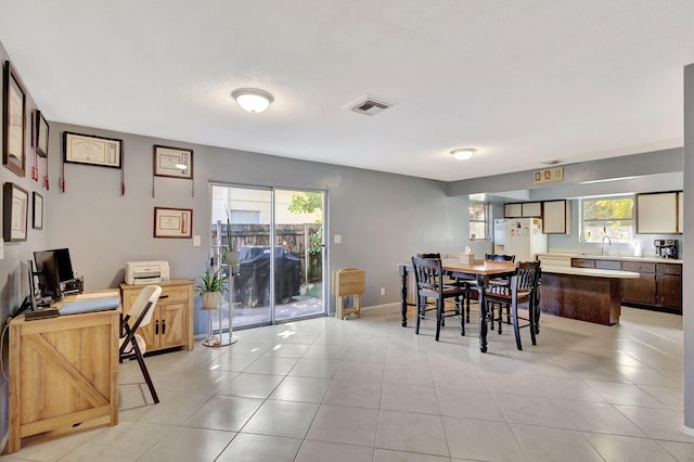 dining area with a wealth of natural light and light tile patterned floors