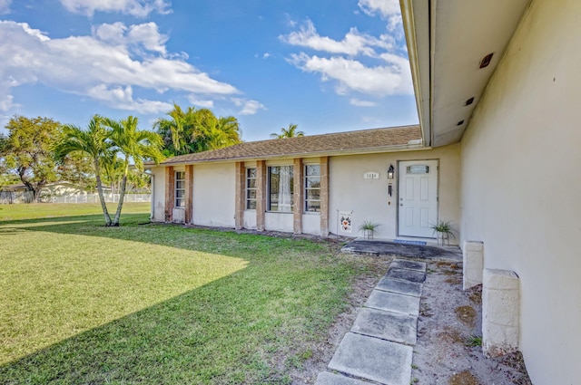 view of exterior entry with a lawn