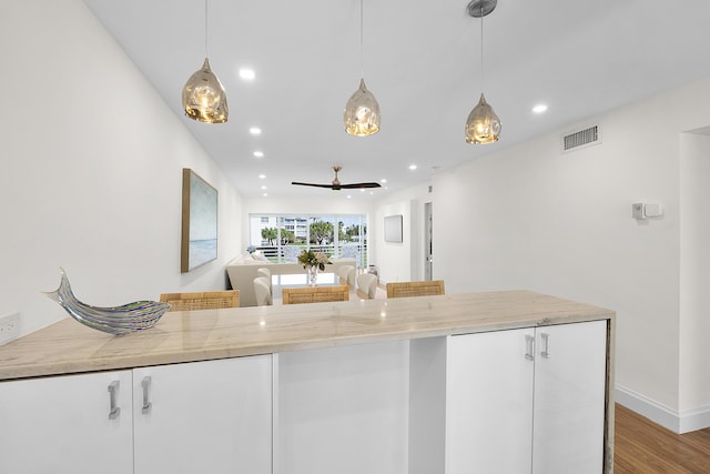 kitchen with a ceiling fan, wood finished floors, visible vents, recessed lighting, and decorative light fixtures