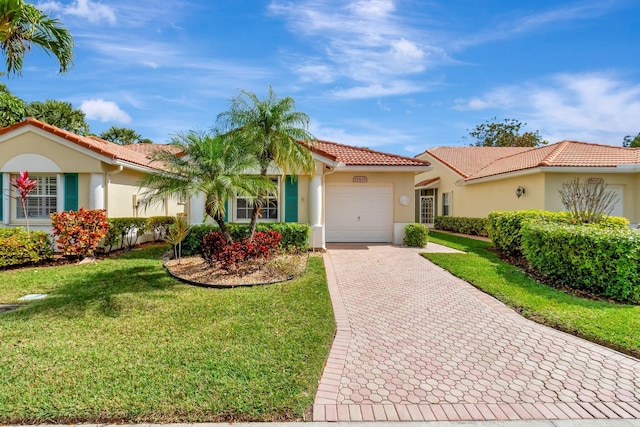 view of front of property with decorative driveway, stucco siding, a front yard, a garage, and a tiled roof