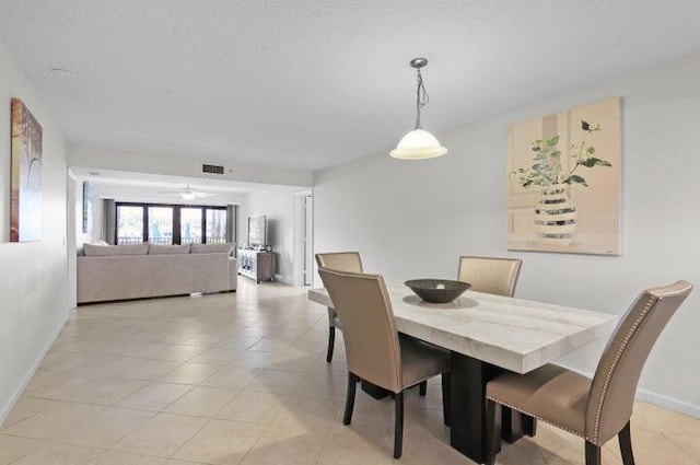 tiled dining room featuring a textured ceiling