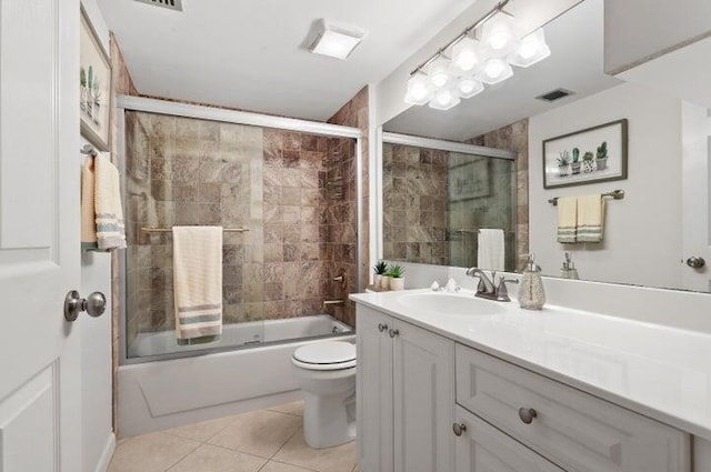 full bathroom with vanity, combined bath / shower with glass door, tile patterned floors, and toilet