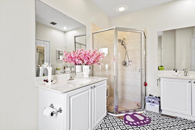 bathroom featuring vanity and a shower with door