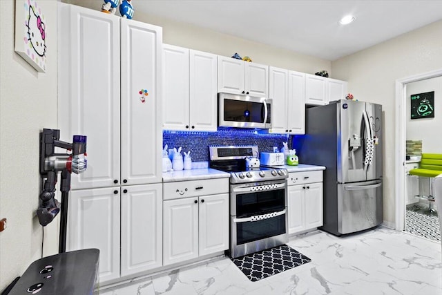 kitchen featuring white cabinetry, decorative backsplash, and appliances with stainless steel finishes