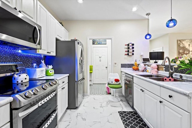 kitchen featuring decorative light fixtures, white cabinetry, sink, decorative backsplash, and stainless steel appliances