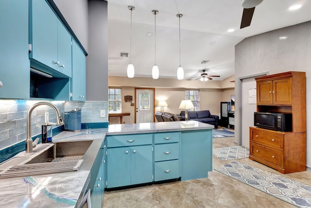 kitchen featuring vaulted ceiling, decorative light fixtures, sink, ceiling fan, and blue cabinetry