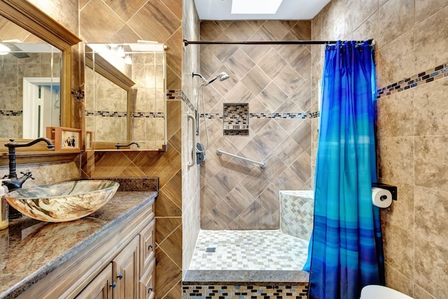 bathroom featuring vanity, curtained shower, and tile walls