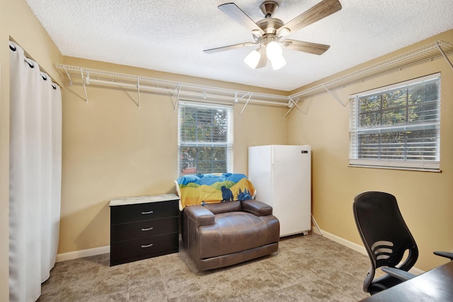 office featuring a textured ceiling and ceiling fan