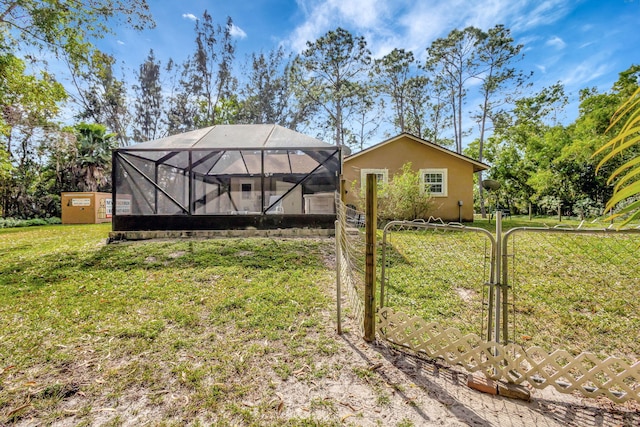 rear view of house with a lanai and a lawn