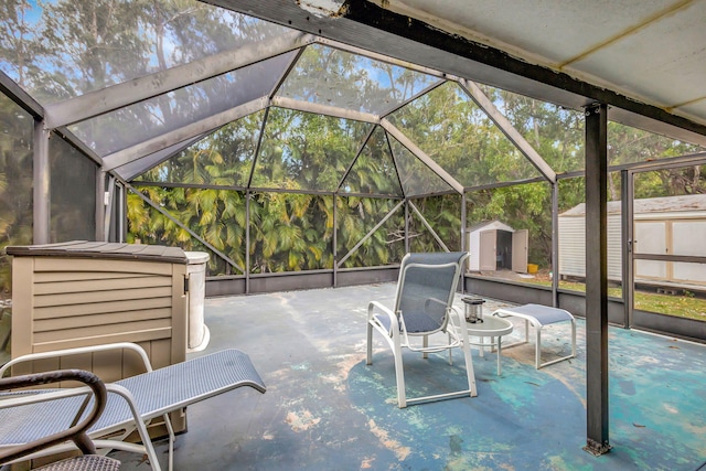 view of patio featuring a storage shed and glass enclosure