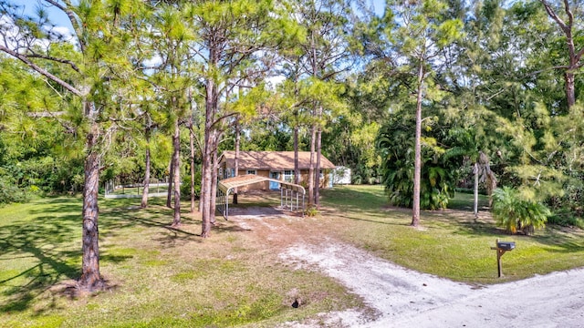 exterior space with a carport and a front lawn