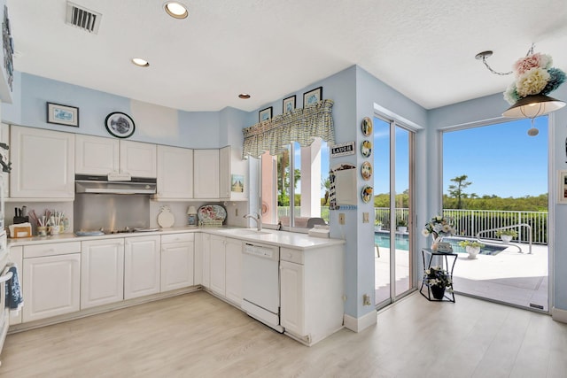 kitchen featuring dishwasher, sink, white cabinets, and light hardwood / wood-style flooring