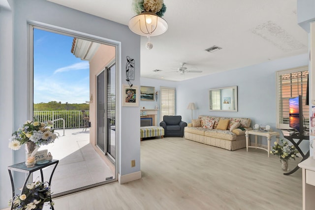 living room featuring light hardwood / wood-style flooring and ceiling fan