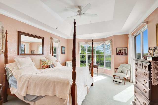 bedroom with crown molding, light colored carpet, a raised ceiling, and ceiling fan